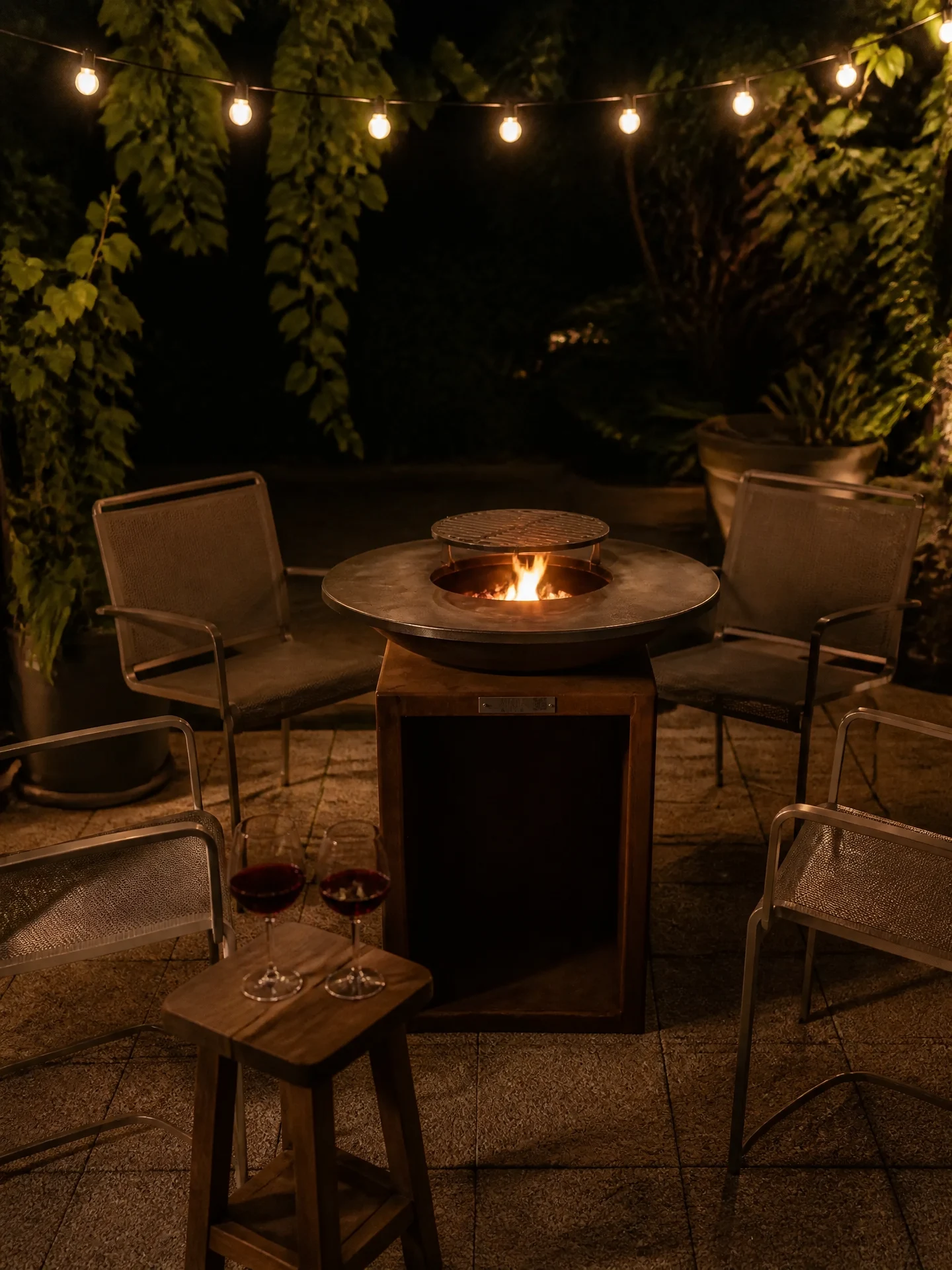 Brasero plancha la nuit, foyer crépitant, ambiance prolongée après le repas